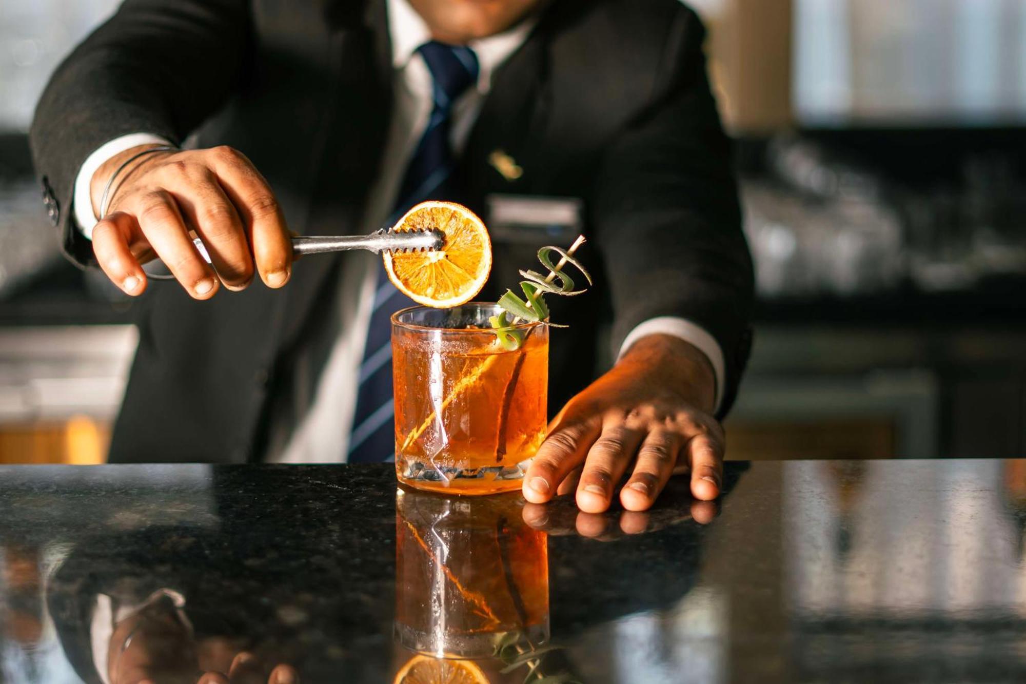 โรงแรมเรดิสัน บลู อมฤตสร อัมริตสา ภายนอก รูปภาพ A bartender preparing a cocktail